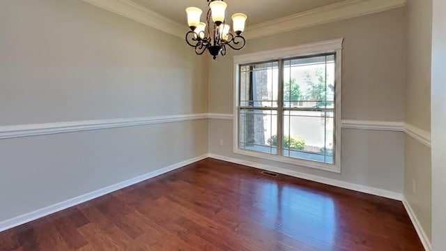 unfurnished room featuring crown molding, dark hardwood / wood-style flooring, an inviting chandelier, and a wealth of natural light