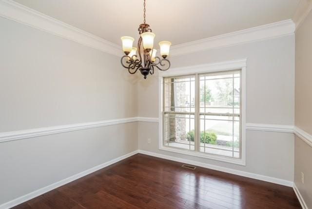 unfurnished room featuring crown molding, dark wood-type flooring, and a chandelier