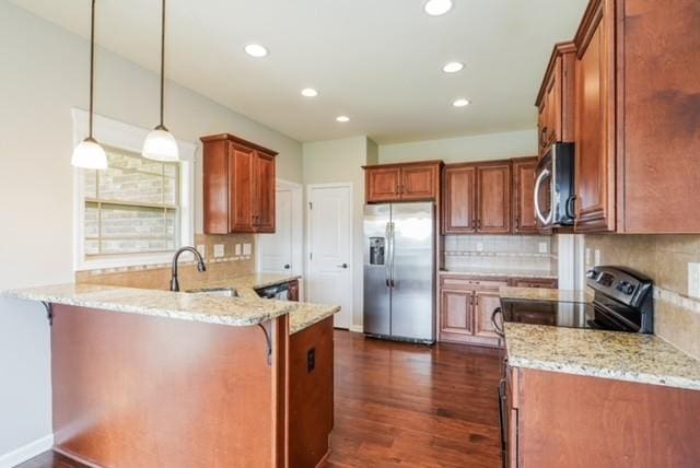 kitchen featuring a breakfast bar, stainless steel appliances, light stone countertops, decorative light fixtures, and kitchen peninsula