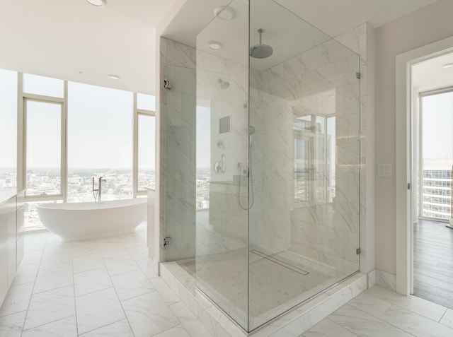 bathroom featuring tile floors, plenty of natural light, and separate shower and tub