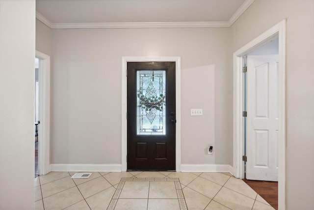 foyer entrance featuring light tile patterned floors and crown molding