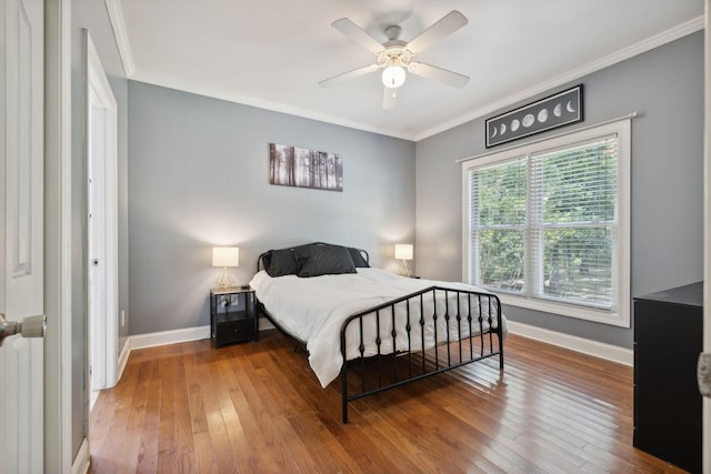 bedroom featuring radiator, hardwood / wood-style flooring, ceiling fan, and crown molding