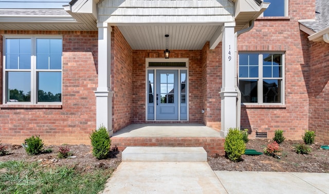 view of exterior entry featuring covered porch