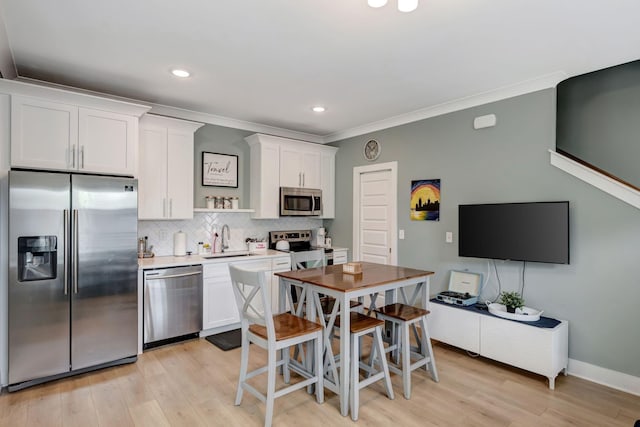 kitchen with stainless steel appliances, white cabinetry, tasteful backsplash, and sink