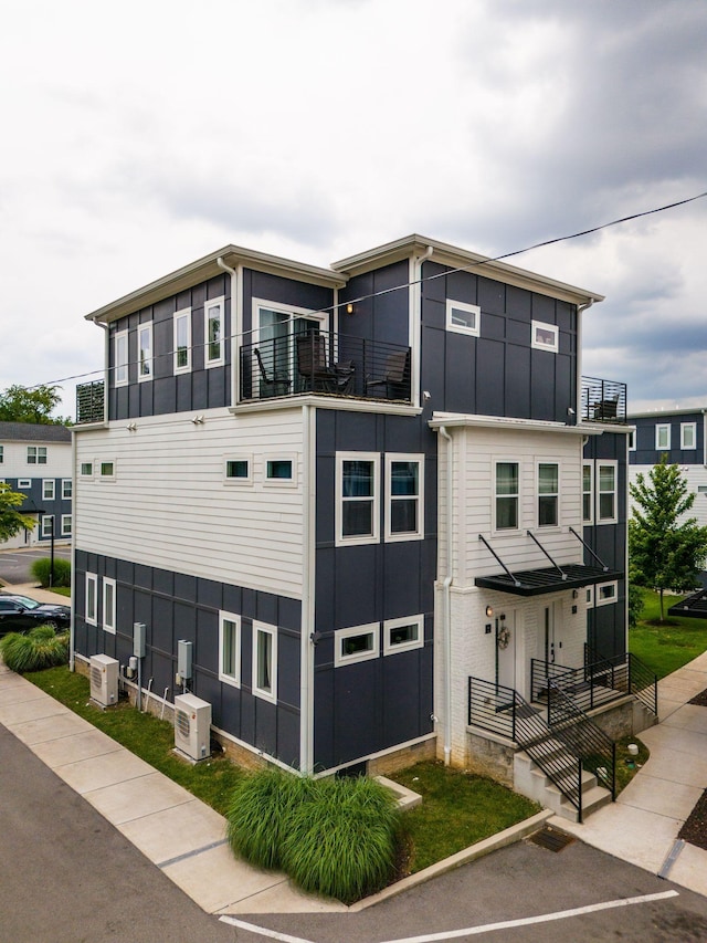 view of front of house with board and batten siding and a balcony