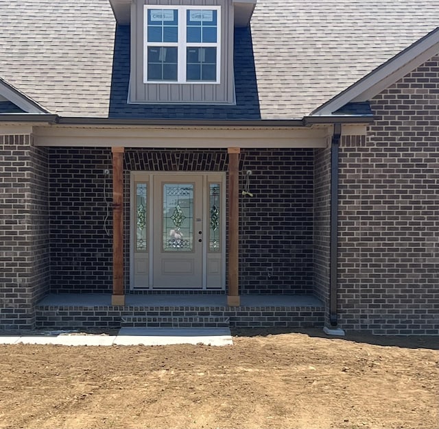 entrance to property with brick siding and roof with shingles