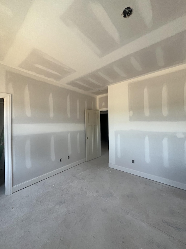 spare room featuring unfinished concrete flooring