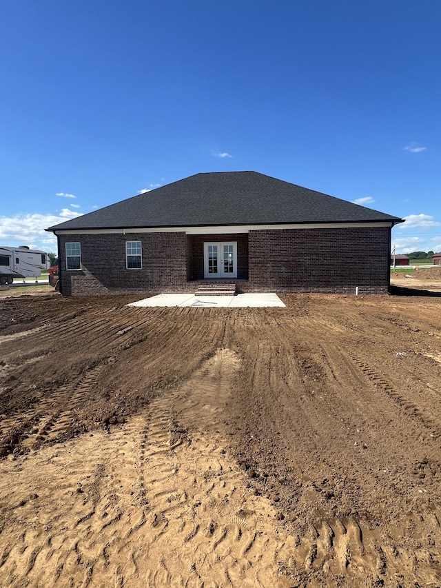 exterior space with brick siding and a patio