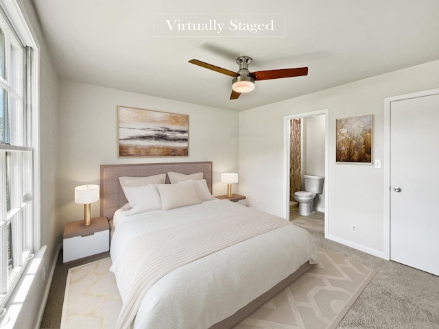 bedroom with ceiling fan, light carpet, and connected bathroom