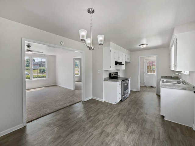 kitchen featuring stainless steel electric range oven, sink, white cabinets, dark carpet, and ceiling fan with notable chandelier