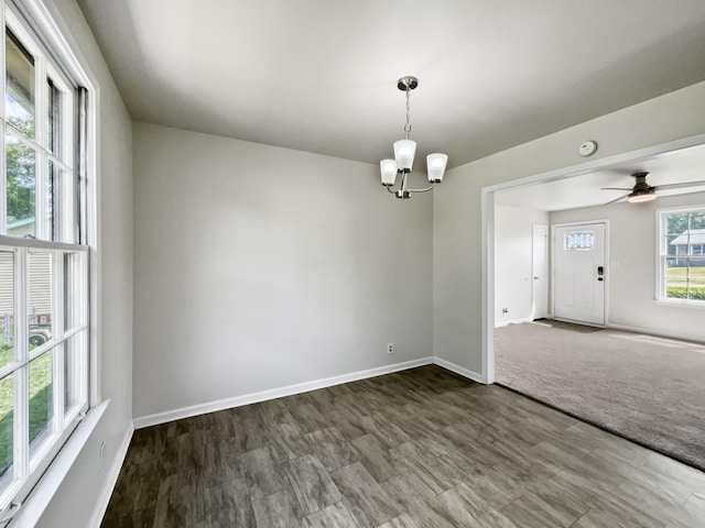 spare room with hardwood / wood-style floors, a healthy amount of sunlight, and ceiling fan with notable chandelier