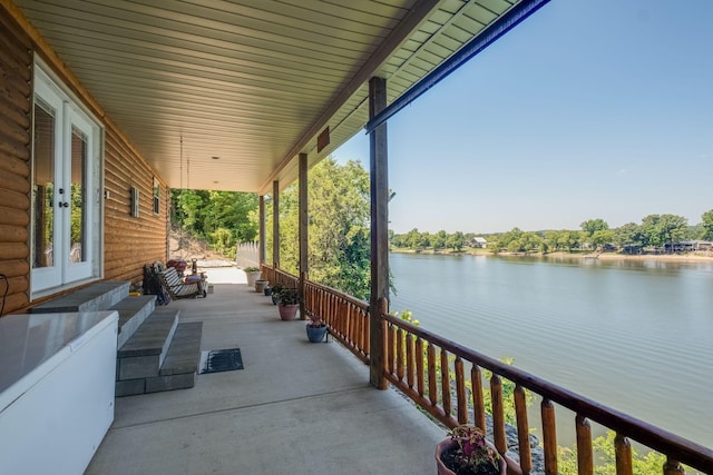 view of patio featuring covered porch, french doors, and a water view