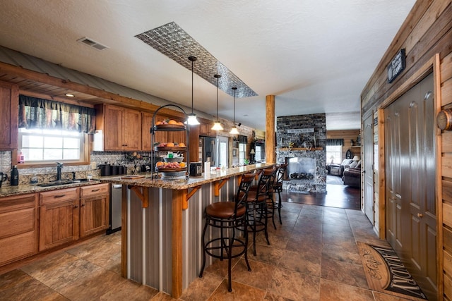 351 New Era Landing Rd, Linden, TN 37096 - kitchen featuring brown cabinets, a breakfast bar, light stone countertops, hanging light fixtures, and open floor plan
