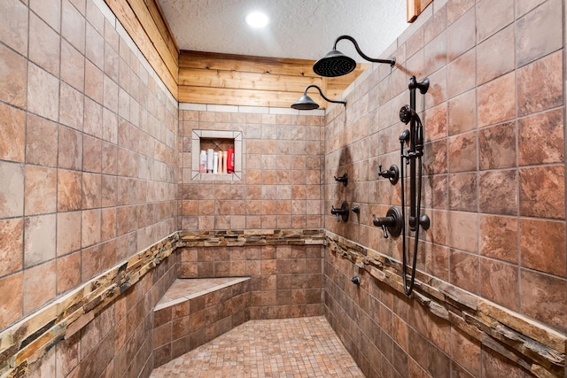 bathroom with a tile shower and a textured ceiling