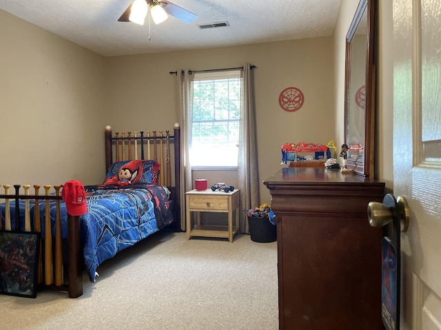 bedroom featuring ceiling fan, carpet, and a textured ceiling