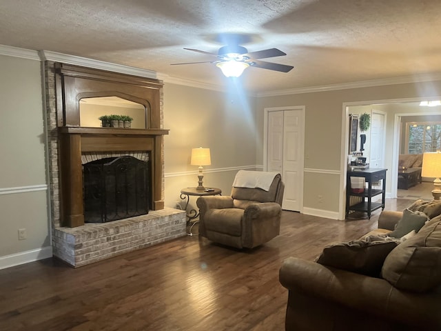 living room featuring dark hardwood / wood-style floors, ceiling fan, crown molding, a brick fireplace, and a textured ceiling