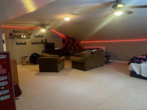 carpeted cinema featuring lofted ceiling and ceiling fan