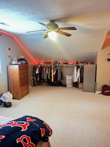 carpeted bedroom with ceiling fan and a textured ceiling