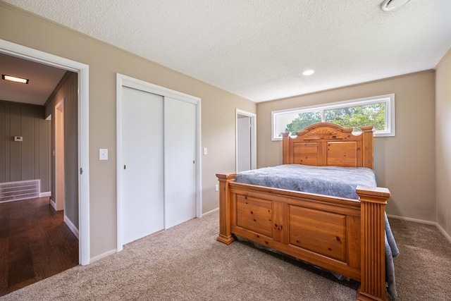 carpeted bedroom with a closet and a textured ceiling