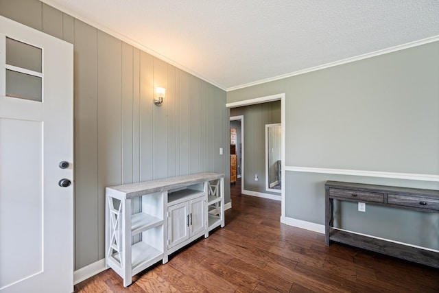 interior space with a textured ceiling, crown molding, and dark wood-type flooring