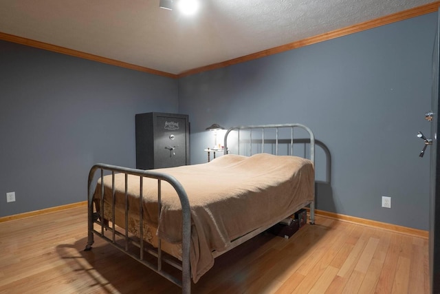 bedroom with light hardwood / wood-style flooring and crown molding