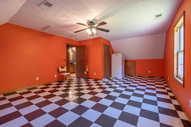 bonus room with a textured ceiling, vaulted ceiling, and ceiling fan