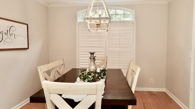 dining area featuring wood-type flooring, crown molding, and an inviting chandelier