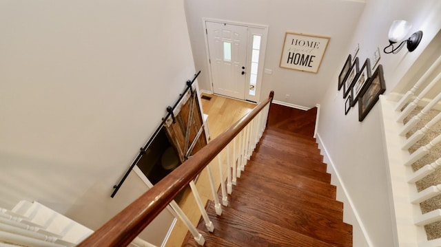 stairway with hardwood / wood-style floors and a barn door