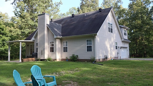 rear view of property featuring a yard and a garage