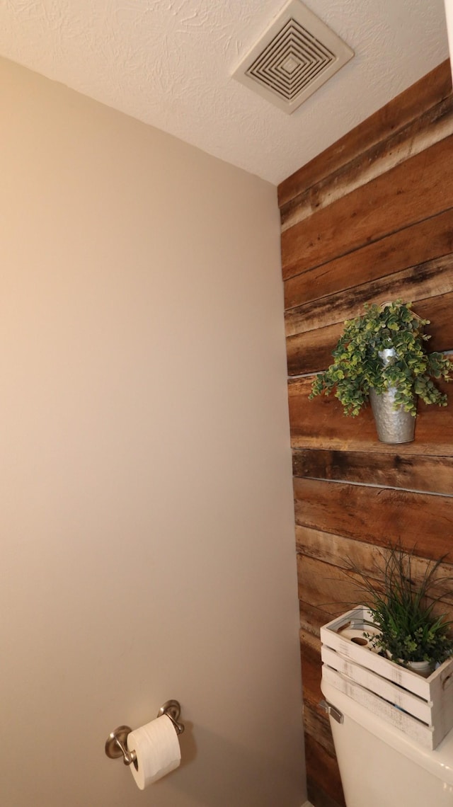 details featuring a textured ceiling and wood walls