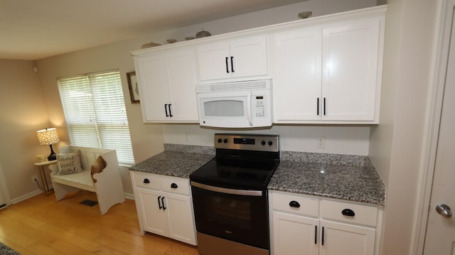 kitchen with dark stone counters, light hardwood / wood-style flooring, white cabinetry, and stainless steel range with electric cooktop