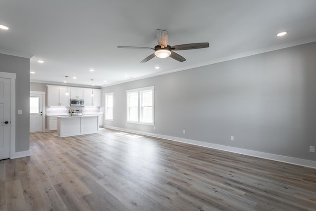 unfurnished living room with ceiling fan, light hardwood / wood-style flooring, and crown molding