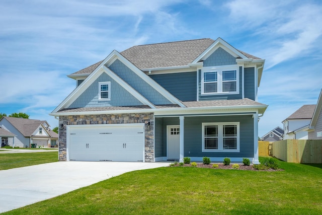 craftsman-style house featuring covered porch, a front yard, and a garage