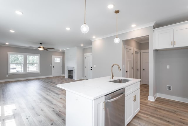 kitchen with dishwasher, white cabinetry, hanging light fixtures, sink, and a center island with sink