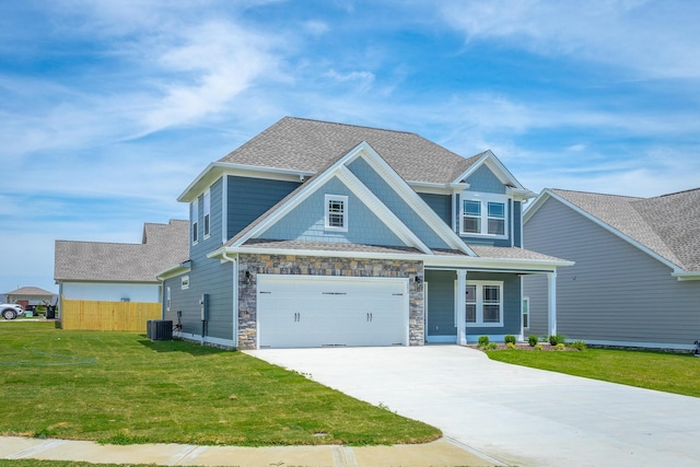 craftsman inspired home with a garage, central air condition unit, and a front lawn