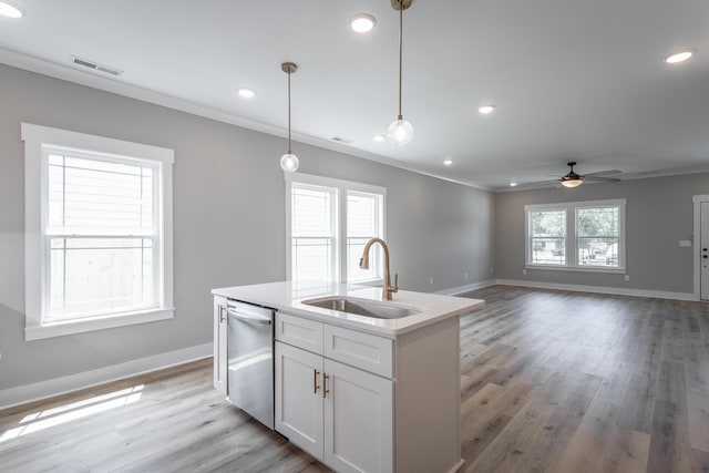 kitchen with crown molding, dishwasher, sink, white cabinets, and decorative light fixtures