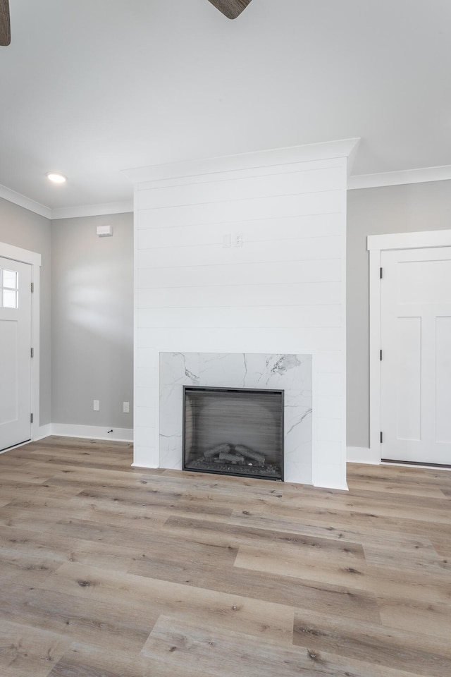 room details with hardwood / wood-style flooring, a high end fireplace, and crown molding