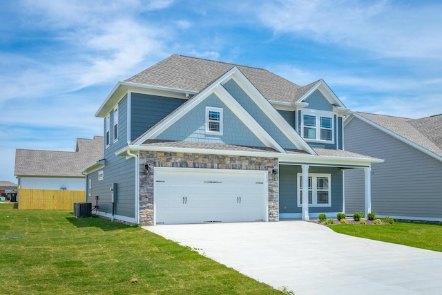 craftsman-style house featuring covered porch, central air condition unit, a front yard, and a garage