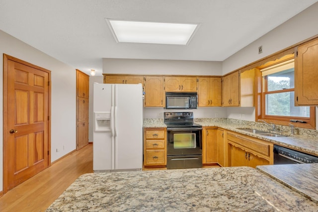 kitchen with sink, light hardwood / wood-style flooring, and black appliances