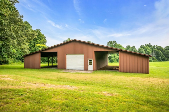 view of outbuilding featuring a yard, a carport, and a garage