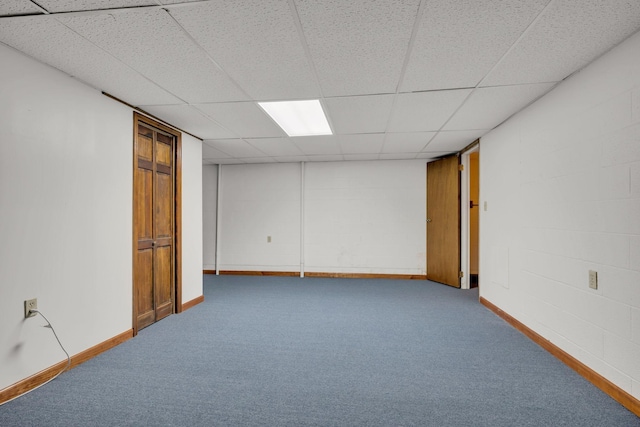 empty room featuring a paneled ceiling and light carpet