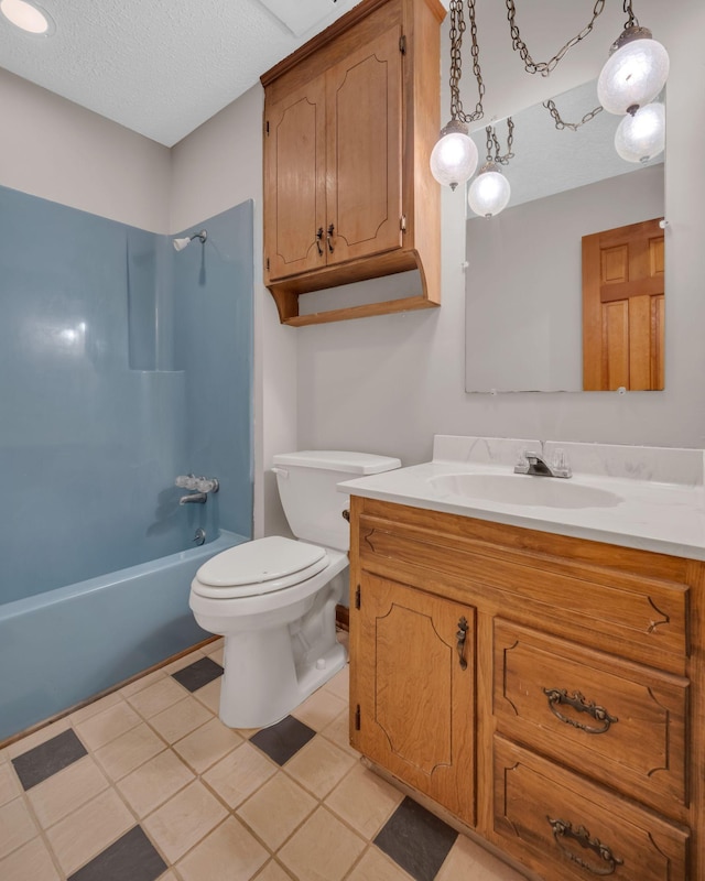 full bathroom featuring tile patterned flooring, bathing tub / shower combination, a textured ceiling, toilet, and vanity