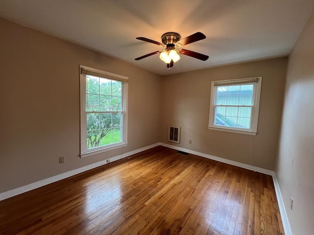 empty room featuring heating unit, ceiling fan, and light hardwood / wood-style floors