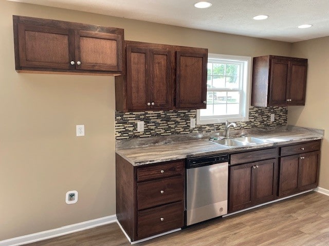 kitchen featuring light hardwood / wood-style floors, stainless steel dishwasher, sink, decorative backsplash, and dark brown cabinetry