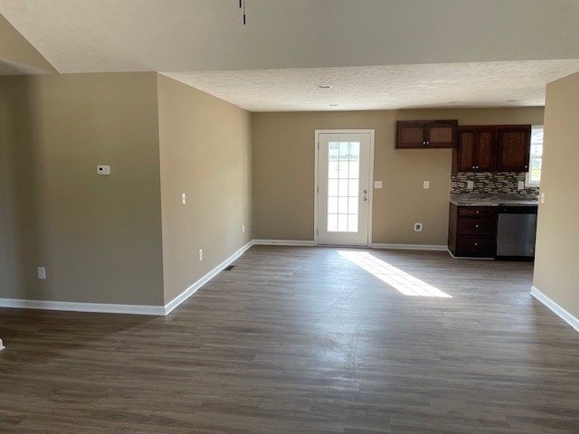 interior space featuring backsplash, dishwasher, dark hardwood / wood-style floors, and a textured ceiling