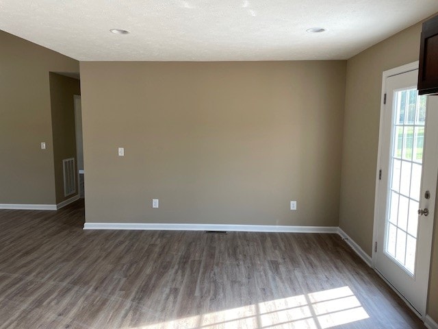 unfurnished room featuring a textured ceiling and hardwood / wood-style floors