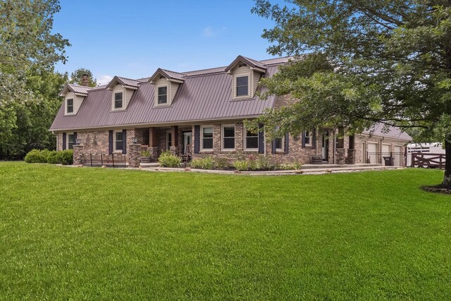 cape cod-style house featuring a front yard and a garage