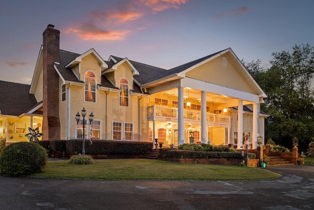 view of front of property with a balcony and a yard