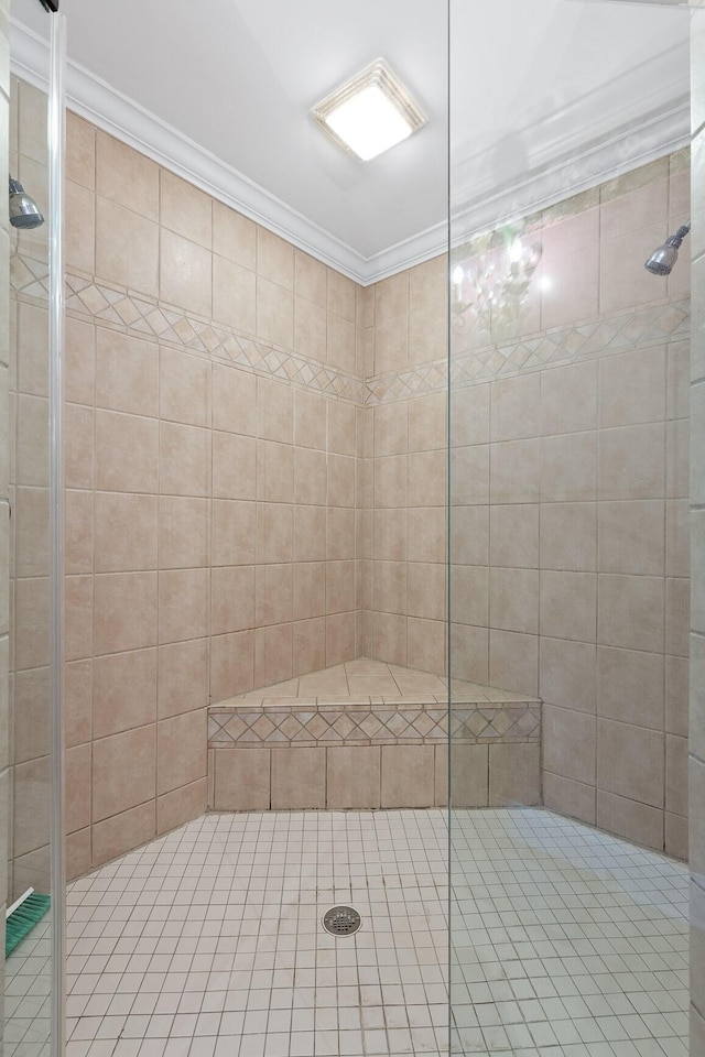 bathroom with crown molding and tiled shower