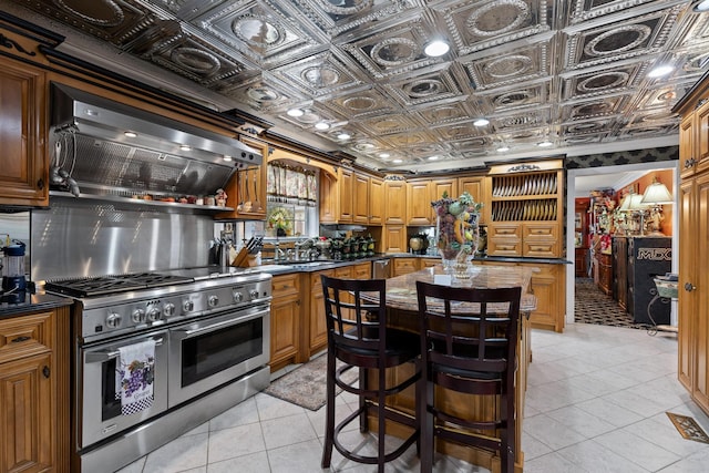 kitchen with sink, custom exhaust hood, a center island, light tile patterned floors, and appliances with stainless steel finishes